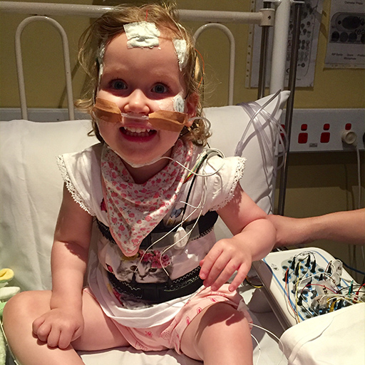 A child sitting on a hospital bed